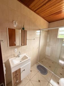 a bathroom with a sink and a shower at Chalés recanto dos oliveira in Camanducaia