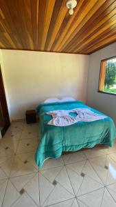 a bed in a bedroom with a wooden ceiling at Chalés recanto dos oliveira in Camanducaia