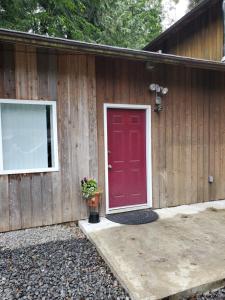 a red door on the side of a house at Rudolph's Reindeer Den in Ketchikan