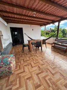 a living room with a wooden floor and a table and chairs at Prédio AZUL in Itacaré