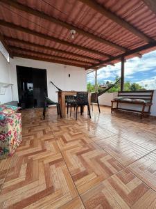 a room with a wooden floor with a table and chairs at Prédio AZUL in Itacaré