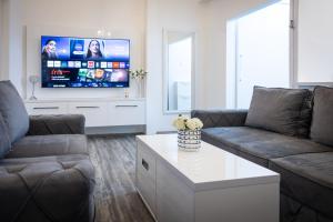 a living room with a couch and a tv at City Square, center in Subotica