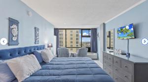 a blue bedroom with a blue bed and a window at Ocean View Suites at Oceanside Inn in Daytona Beach