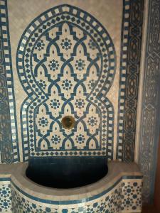 a blue and white tile wall with a fountain at Saidia luxury in Saïdia