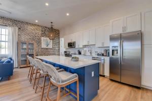 a kitchen with a large island with chairs and a refrigerator at Harbor House Penthouse- B in Key West