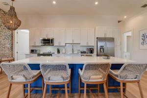 a kitchen with white cabinets and a counter with chairs at Harbor House Penthouse- B in Key West +26 photos