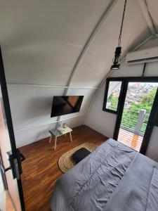 a bedroom with a bed and a tv in a room at Hebe Hotel, Hostel & Hospitality Network in Sawah