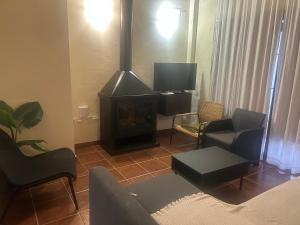 a living room with a fireplace and a tv at La Escapada in El Ronquillo