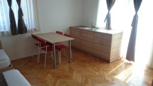a kitchen with a table and two chairs and a sink at Postojna Rooms in Postojna