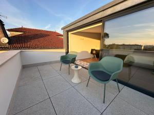 a balcony with two chairs and a bed on a roof at Loft Azeméis in Oliveira de Azemeis +6 photos