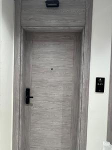 a wooden door in a white room with aestamp at اجنحة راف السلام in Medina