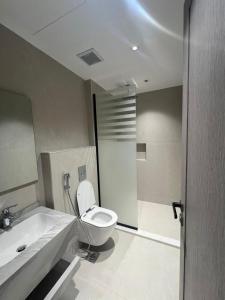 a bathroom with a toilet and a sink at اجنحة راف السلام in Medina