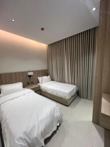 a hotel room with two beds and a window at اجنحة راف السلام in Medina