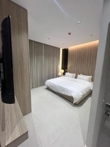 a bedroom with a bed and a flat screen tv at اجنحة راف السلام in Medina