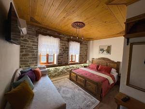 a bedroom with a bed and a couch in a room at Stone Pazar Guest House in Gjirokastër