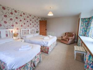 a hotel room with two beds and a chair at Ghyll Bank House in Staveley