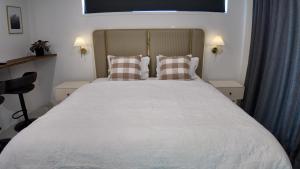 a bedroom with a large white bed with two pillows at Taupo Premium Retreat - Private Spa & Ensuite in Taupo