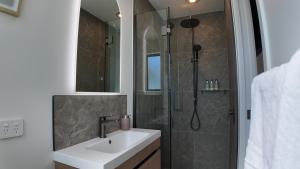 a bathroom with a sink and a shower at Taupo Premium Retreat - Private Spa & Ensuite in Taupo +14 photos