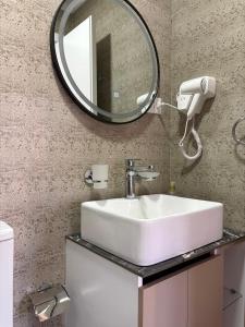 a bathroom with a sink and a mirror at Stone Pazar Guest House in Gjirokastër