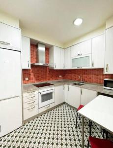 a kitchen with white cabinets and a black and white tile floor at Casa dos Cantares in Padrón +17 photos