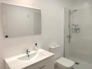 a bathroom with a sink and a toilet and a mirror at Casa dos Cantares in Padrón