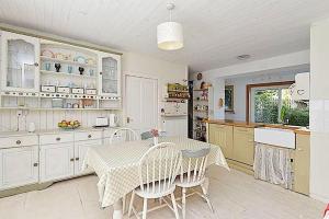 a kitchen with a table and chairs in a room at Charming Old Cottage for Share, Cosy Double Room with 2 Single Bed in Edinburgh