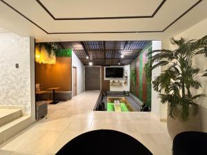 an office lobby with a tv and a plant at Santa Barbara Central Suites in Bogotá