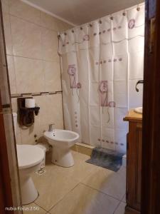 a bathroom with a toilet and a shower curtain with flowers at Complejo Rancho Grande in Nueva Atlantis +6 photos