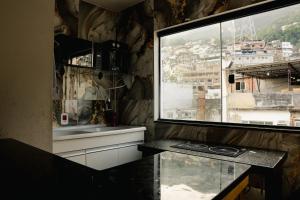 a kitchen with a window and a counter with a sink at Favela Hostel in Rio de Janeiro