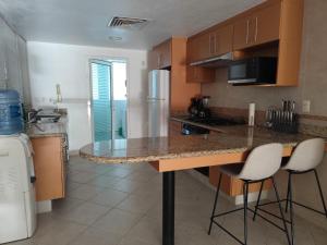 a kitchen with a counter and two bar stools at IXTAPA LUXURY - BVG 405 Norte in Ixtapa
