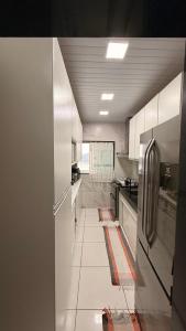 a kitchen with white cabinets and a refrigerator at Casa vista infinita in Mangaratiba