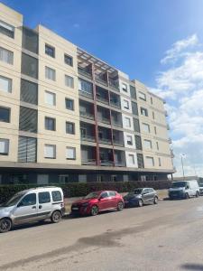 a large building with cars parked in front of it at Airport Luxury Residence Taj collection 1 in Casablanca