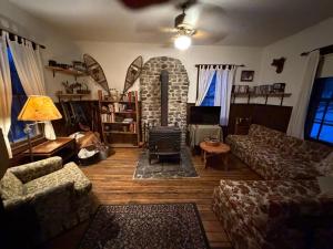 a living room with a couch and a stone fireplace at Adirondack Butterfly Hillside in North Creek