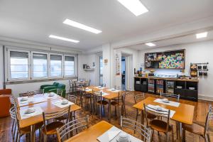 a restaurant with tables and chairs in a room at HI Coimbra - Pousada de Juventude in Coimbra