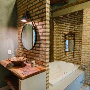 a bathroom with a sink and a tub and a mirror at Chalé Tororão - São Jorge GO in Sao Jorge +54 photos