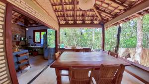a dining room with a large wooden table and chairs at Chalé Tororão - São Jorge GO in Sao Jorge