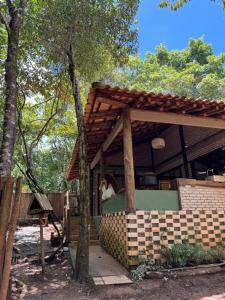 a house with a porch with a roof at Chalé Tororão - São Jorge GO in Sao Jorge