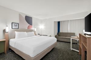 a hotel room with a large bed and a couch at Spark by Hilton Chattanooga Downtown in Chattanooga