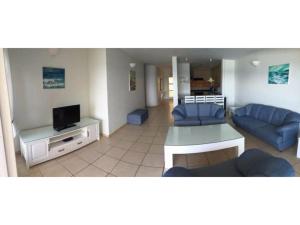 a living room with a couch and a tv at Sorgente 305 in Umdloti