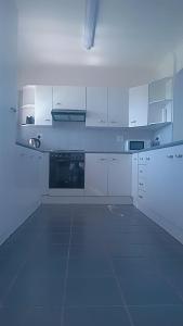 a large white kitchen with white cabinets and appliances at white house Bluewaterbay in Gqeberha