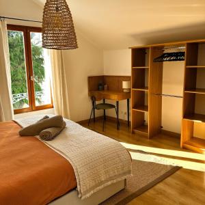 a bedroom with a bed and a desk and a window at Echappée Bleue in Auvers-sur-Oise