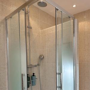 a shower with a glass door in a bathroom at Echappée Bleue in Auvers-sur-Oise