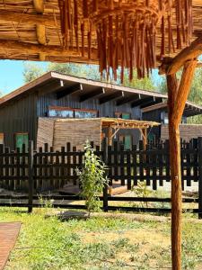 a wooden fence in front of a building at Tiny House Al lado del río in Linares +12 photos