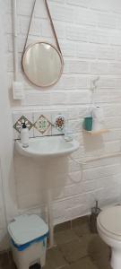 a white bathroom with a sink and a toilet at La foca da Croa in Goiana