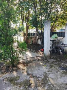 a garden with a table and a fence and trees at Fabylu in Ezpeleta