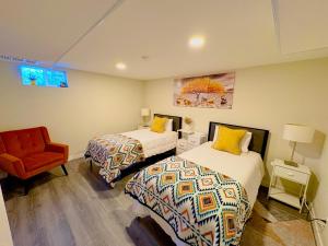 a bedroom with two beds and a red chair at Private Residence Below Basement in Thornton +15 photos