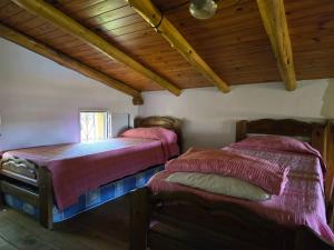 two beds in a room with wooden ceilings at Cabaña La Joaquina in Colón +38 photos