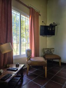 a living room with two chairs and a table and a tv at Cabaña La Joaquina in Colón