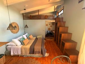 a bedroom with a bed and a spiral staircase at Tiny House Detrás del río in Colbún