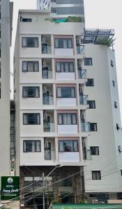 a tall white apartment building with balconies at Happy Beach Hotel in Nha Trang